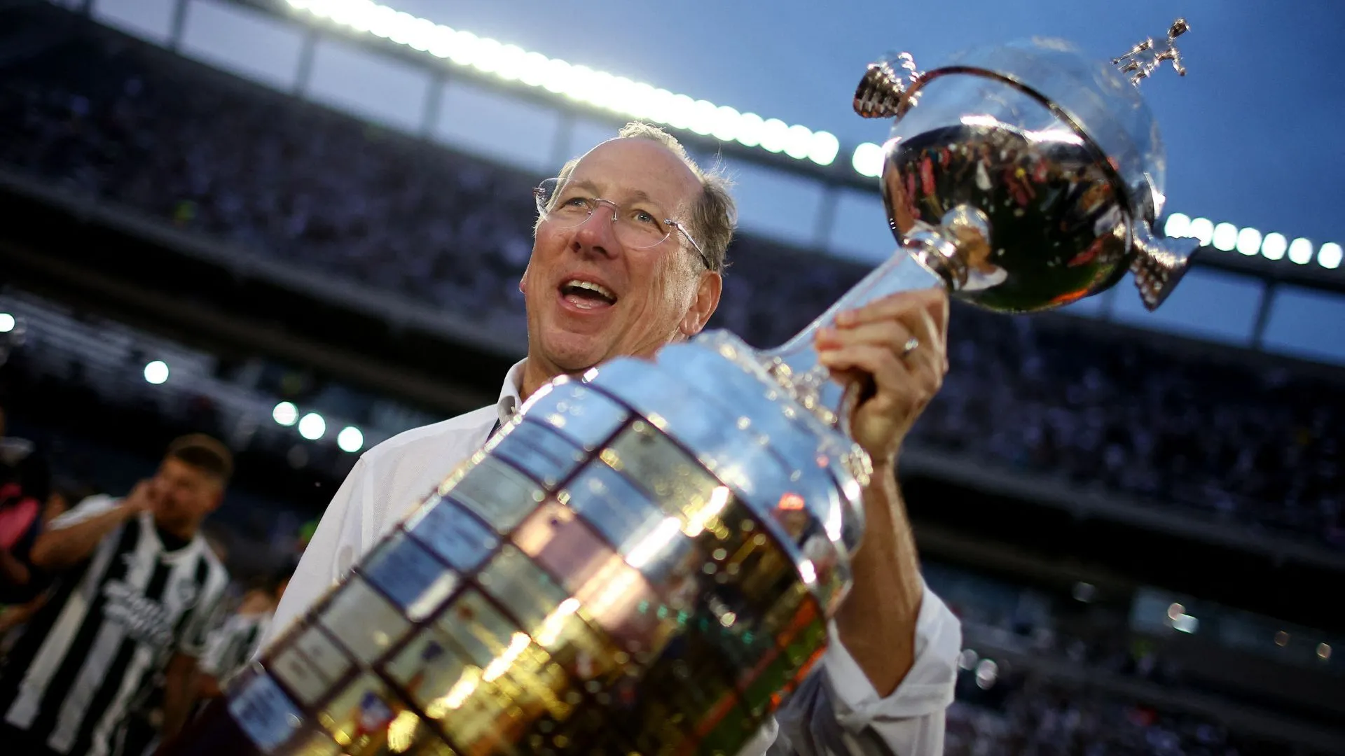 Doanh nhân John Textor cùng chiếc cúp Copa Libertadores, thể hiện kinh nghiệm điều hành các câu lạc bộ bóng đá